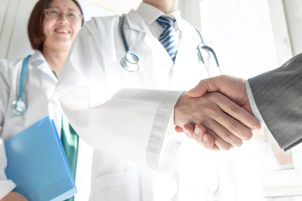 Physician and consultant shaking hands after a meeting